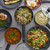 Set of grey non-stick saucepans with various cooked dishes, shown from above