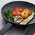 Non-stick frying pan with grilled broccoli, peppers, aubergine, and courgette slices