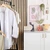 Handheld clothes steamer on counter beside hanging shirts, suitable for home garment care.