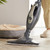 Grey upright steam mop cleaning wood floor near pet bed