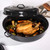 Black enamel roasting set with lids, shown with roast and roasted vegetables on kitchen counter
