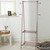 Bronze metal clothes airer with two tiers and side arms, shown in a modern room.