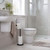 Black toilet roll holder with three rolls in modern bathroom setting