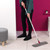 Microfibre flat mop with pink handle cleaning light wood floor in modern room