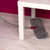 Flexible microfibre mop cleaning under white table on light wood floor