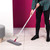 Grey flat mop with white and pink handle in use on light wood floor