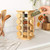 Rotating bamboo spice rack with glass jars on kitchen worktop, hand picking jar