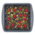 Tray of chocolate brownies topped with raspberries and chopped pistachios