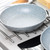 Grey non-stick frying pan with speckled finish on stainless steel hob