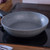 Grey non-stick frying pan on hob, angled view