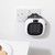 Plug-in mini heater in white and black, shown in use on UK wall socket