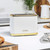White and gold two-slice toaster on kitchen counter, modern ribbed design.