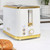 White and gold two-slice toaster with ribbed design in kitchen setting