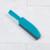Blue plastic grout brush with grey bristles on white tiled floor