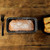 Loaf cake dusted with icing sugar in baking tin, with sliced portion on plate.