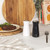 Black Salter salt shaker held in hand, angled for use