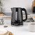 Black electric kettle with water level window, on kitchen counter