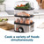 Three-tier food steamer cooking eggs, salmon and vegetables simultaneously