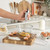 Hand using silver electric whisk to beat eggs in glass bowl on kitchen counter