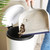 Large dustpan emptying soil and debris into white kitchen bin