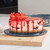 Strawberry cheesecake with biscuit base and strawberry topping on serving plate