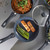 Non-stick frying pan with cooked salmon fillets and asparagus, overhead view