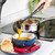 Black ladle serving orange soup into blue bowl with bread, for kitchen utensil listing