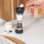 Dual salt and pepper grinder with black and stainless steel finish, shown on kitchen counter.