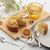 Round citrus cake with dried lemon slices, served with a glass of tea and dessert spoons