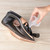 Rose gold and black cordless steam iron being filled with water from jug