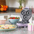 Purple mini doughnut maker on kitchen counter with decorated doughnuts and sprinkles