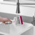 Pet hair remover roller being rinsed under tap in kitchen sink