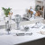 Selection of silver kitchen appliances on white worktop, including blender, mixer and hand blender