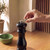 Black pepper mill with hand placing a cap on top
