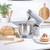 Silver stand mixer with bowl on countertop beside loaf of bread and cake