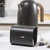 Matte black metal kettle and matching tea caddy with rose gold handle on kitchen counter