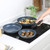 Set of three blue speckled frying pans with detachable handle, shown cooking on hob.