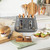 Close-up of grey toaster with two crumb trays partially open showing crumbs