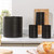 Set of three black tea, coffee, sugar canisters with matching bread bin on kitchen counter