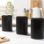 Set of three black kitchen canisters labelled sugar, coffee, and tea on worktop