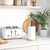 White four-slice toaster with wood accents on kitchen counter, next to paper towel holder