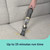 Handheld vacuum cleaning crumbs from a grey fabric sofa