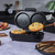 Black electric egg cooker with open lid showing two non-stick poaching trays