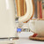 Cream electric kettle switched on, shown next to teacup and tea bag