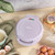 Purple donut maker with seven golden donuts, some decorated donuts and sprinkles nearby