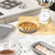 Round non-stick cake pan with baked apple cake on kitchen counter, baking accessories nearby