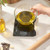 Electronic kitchen scale weighing glass bowl with oil, shown on countertop.
