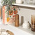 Salter wood salt or pepper grinder on kitchen shelf with cookbooks and glassware