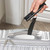 Digital luggage scale weighing silver hard-shell suitcase by the handle