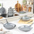 Set of grey non-stick frying pans, saucepans and grill pan on white kitchen worktop